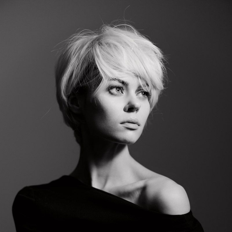 Foto en blanco y negro de una chica rubia con un corte de pelo corto.